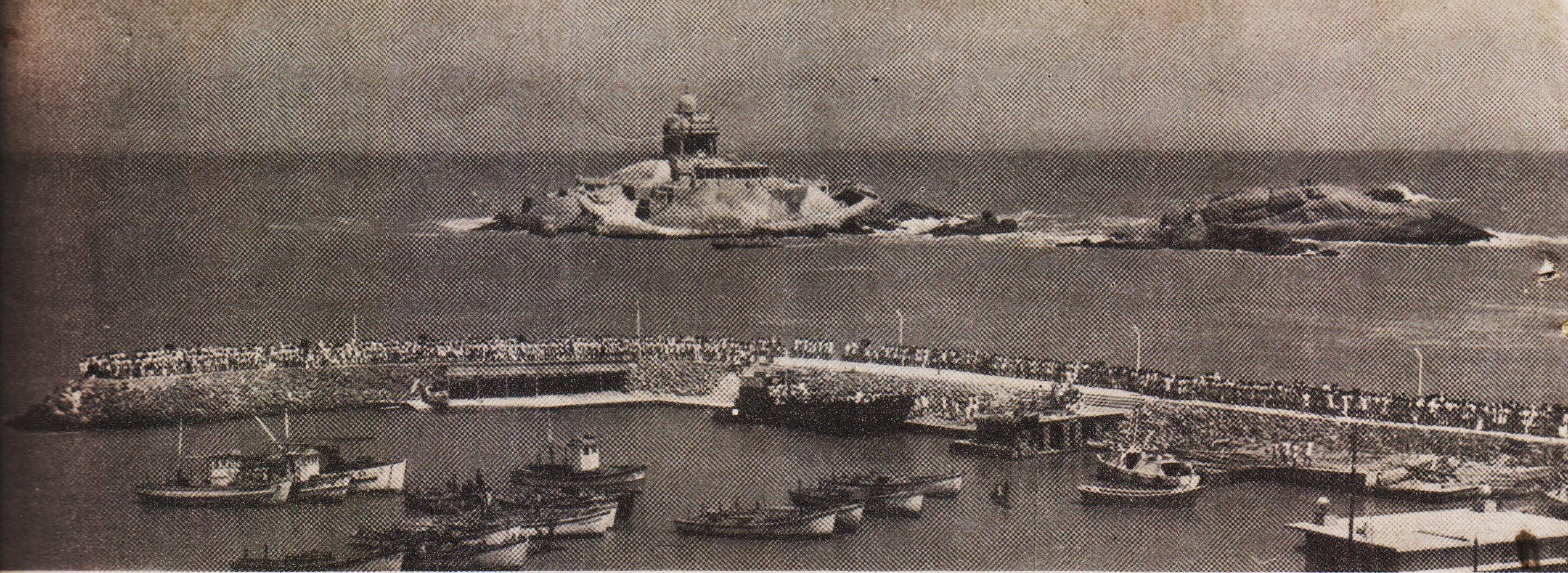 A long line of visitors standing in queue near the jetty-platforms on the Kanyakumari shore, waiting for their chance to board boats to ferry them to the Vivekananda Rock.